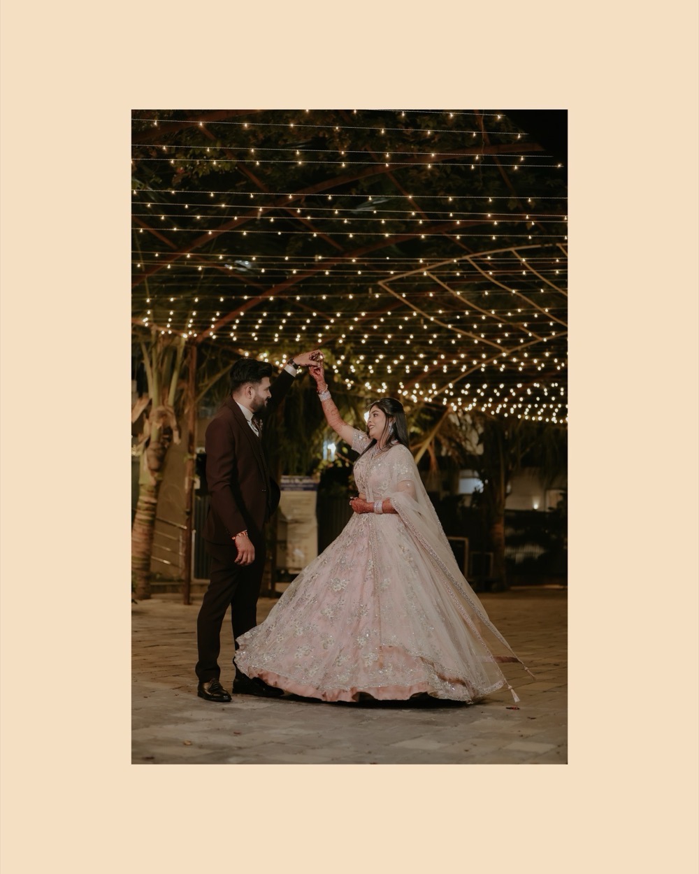 Couple dancing beneath a canopy of fairy lights at their reception